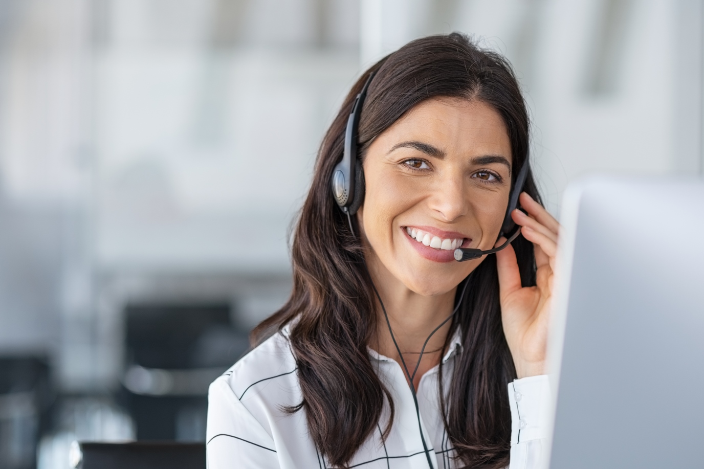 Callcenter-Mitarbeiter mit Kopfhörern, der an der Support-Hotline in modernem Büro arbeitet.
