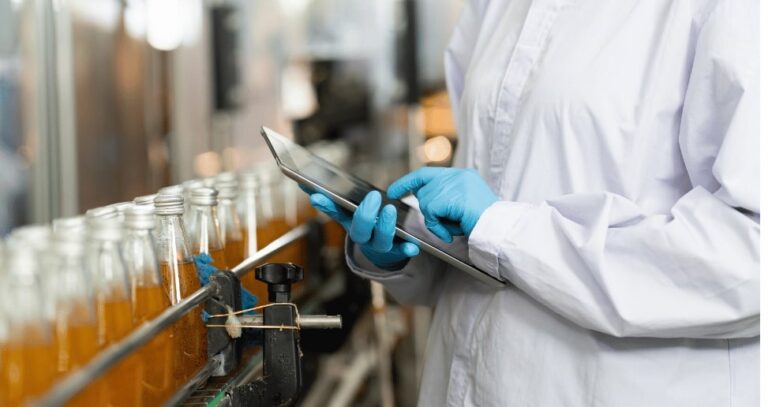 Die Hände eines Arbeiters arbeiten mit einem digitalen Tablet, um das Labor-Informations-Management-System STARLIMS in einer Getränkefabrik zu überprüfen